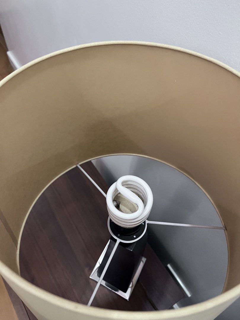 Modern Table Lamp with Curved Black Base and Beige Shade (Category: Lighting) located in Manila. Submitted by this_is_my_closet (Listing ID 1467525045, Image 3). Description: Table lamp featuring a curved black textured body, chrome base plate, and large beige tapered shade. Includes a spiral compact fluorescent bulb. Cord has an inline switch and standard plug. Total height sits around two feet. Neutral tones fit bedside tables or living room de