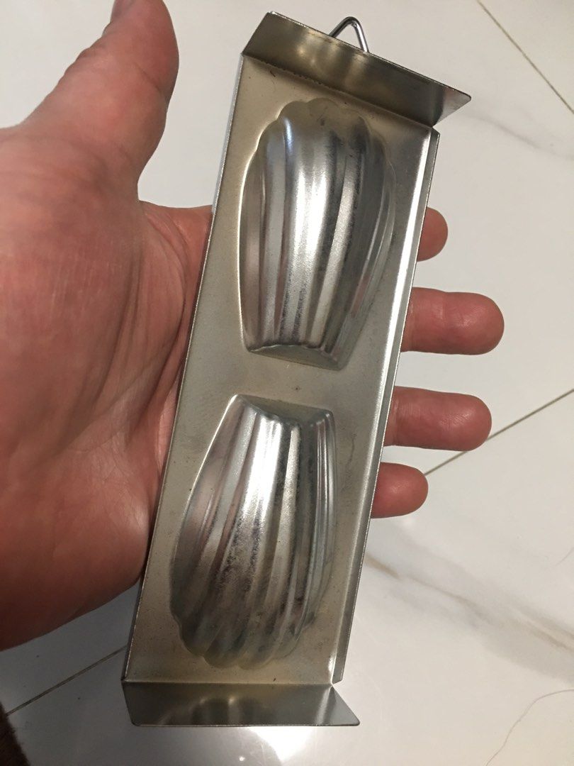 Mon Chere Madeleine Baking Mold Shell Pan (Category: Bakeware) located in Pasay City. Submitted by gilbertso62551 (Listing ID 1467486096, Image 2). Description: - Authentic Mon Chere metal baking pan - Features two shell cavities for making classic French madeleines - Durable silver-tone metal build with brand logo stamped on the bottom edge - Convenient hanging loop for easy kitchen storage - Clean condition and ready for your next baking sessio