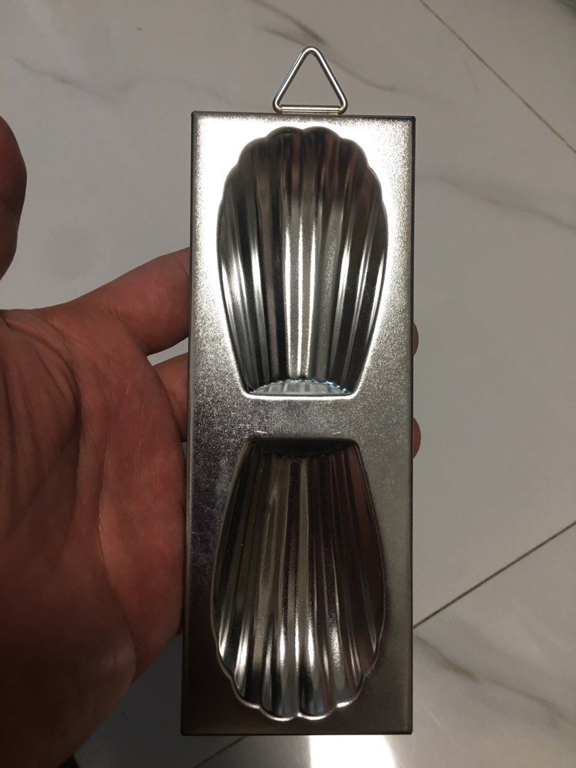 Mon Chere Madeleine Baking Mold Shell Pan (Category: Bakeware) located in Pasay City. Submitted by gilbertso62551 (Listing ID 1467486096, Image 1). Description: - Authentic Mon Chere metal baking pan - Features two shell cavities for making classic French madeleines - Durable silver-tone metal build with brand logo stamped on the bottom edge - Convenient hanging loop for easy kitchen storage - Clean condition and ready for your next baking sessio