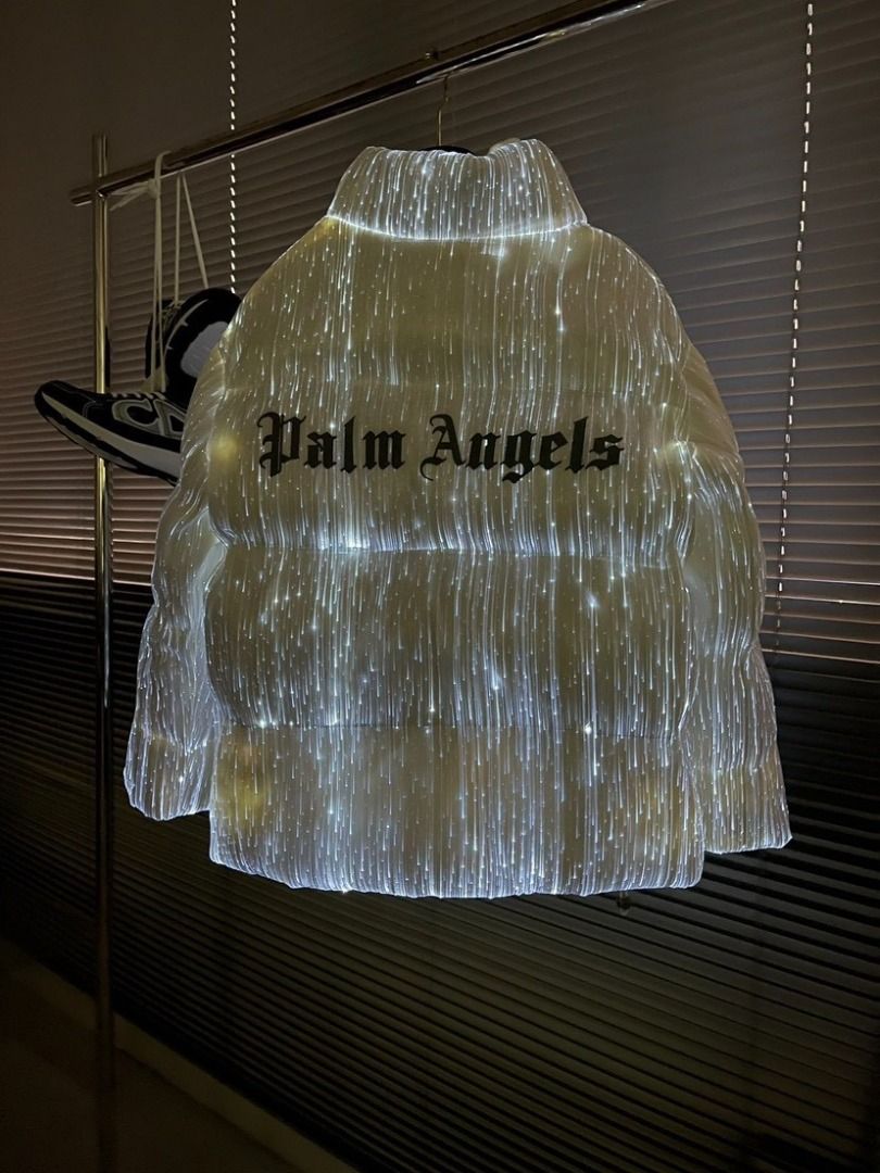 Moncler x Palm Angels LED Light Up Puffer Jacket (Category: Coats, Jackets and Outerwear) located in Pateros City. Submitted by keenriver2de (Listing ID 1467468133, Image 3). Description: - Brand: Moncler x Palm Angels Collaboration - Color: White with embedded glowing fiber optic lights - Details: Moncler chest badge, bold Palm Angels back lettering - Design: Stand-up collar, front zip closure - Condition: Brand new with hang tag still attached.