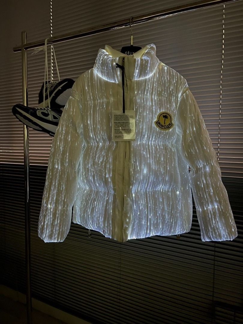 Moncler x Palm Angels LED Light Up Puffer Jacket (Category: Coats, Jackets and Outerwear) located in Pateros City. Submitted by keenriver2de (Listing ID 1467468133, Image 1). Description: - Brand: Moncler x Palm Angels Collaboration - Color: White with embedded glowing fiber optic lights - Details: Moncler chest badge, bold Palm Angels back lettering - Design: Stand-up collar, front zip closure - Condition: Brand new with hang tag still attached.