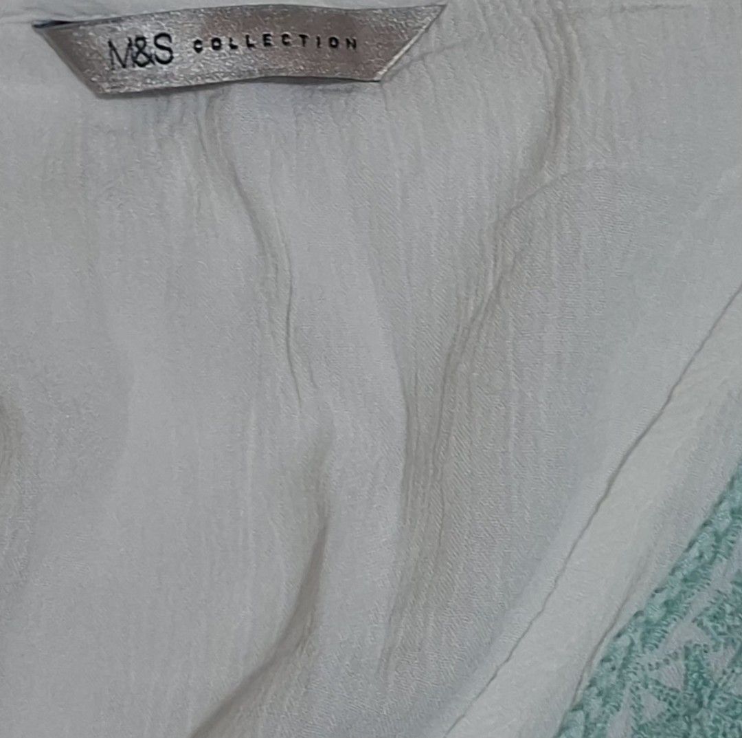 Marks & Spencer Embroidered Boho Blouse (White/Teal) - Great Condition (Category: Blouses) located in Quezon City. Submitted by MP_Declutters (Listing ID 1467433729, Image 2). Description: Description: ✨ M&S Collection Boho-Chic Blouse ✨ Brand: Marks & Spencer (M&S Collection) Color: White base with beautiful teal/mint green geometric embroidery Style: V-neckline with intricate embroidery along the shoulders, empire waist stitching, and breezy fl