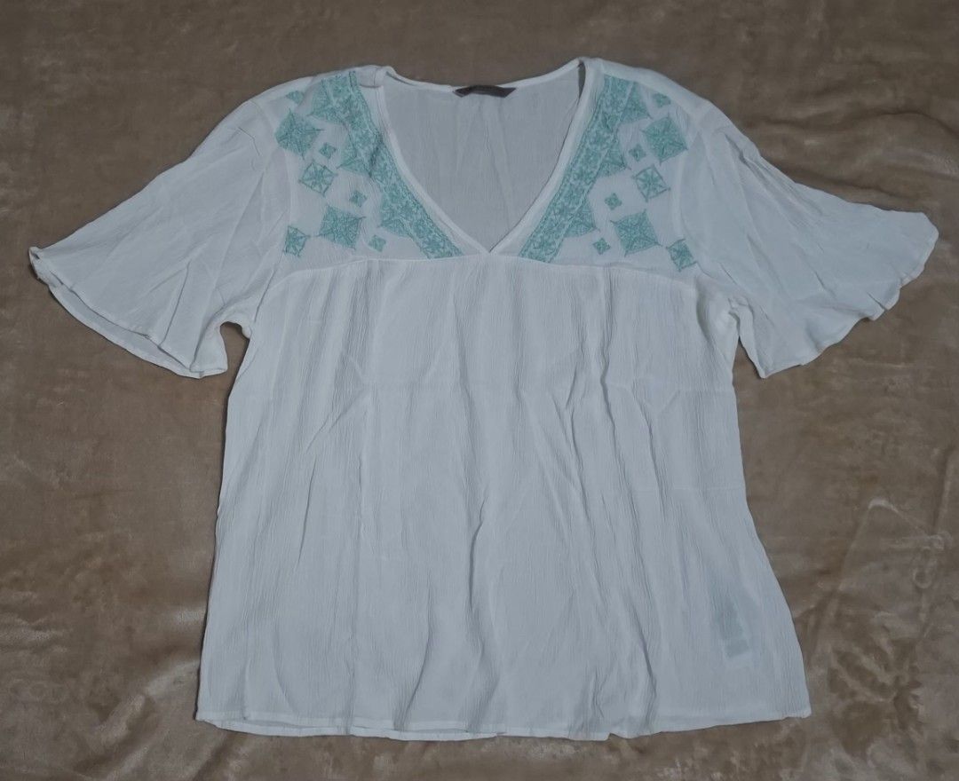 Marks & Spencer Embroidered Boho Blouse (White/Teal) - Great Condition (Category: Blouses) located in Quezon City. Submitted by MP_Declutters (Listing ID 1467433729, Image 1). Description: Description: ✨ M&S Collection Boho-Chic Blouse ✨ Brand: Marks & Spencer (M&S Collection) Color: White base with beautiful teal/mint green geometric embroidery Style: V-neckline with intricate embroidery along the shoulders, empire waist stitching, and breezy fl