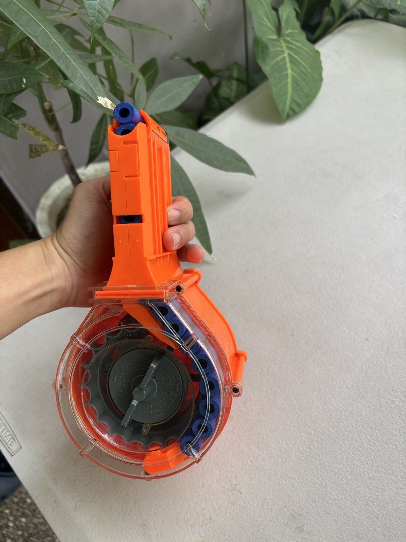 Nerf N-Strike Elite 25-Dart Drum Magazine (Category: Action & Battle Toys) located in Paranaque City. Submitted by marketbasket (Listing ID 1467544849, Image 2). Description: - Genuine orange Nerf drum magazine for N-Strike Elite blasters - High capacity: holds up to 25 darts - Clear back panel for quick and easy ammo checks - Built-in front winding crank ensures smooth dart feeding - Compatible with all standard clip-system Nerf blasters - Great