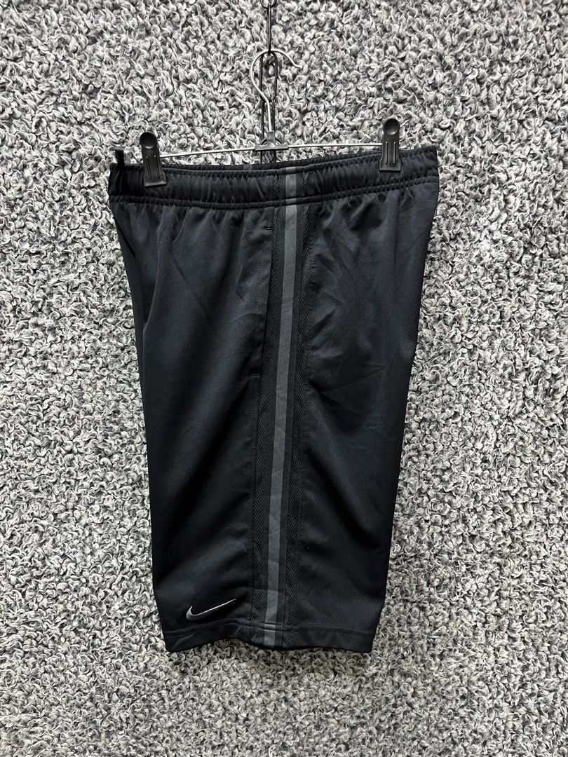 Nike athletic training shorts | Size L (Category: Shorts) located in General Trias. Submitted by zrchustle.604 (Listing ID 1467488649, Image 1). Description: Nike athletic training shorts featuring a vertical stripe down the side, an elastic drawstring waistband, and a grey or silver Nike Swoosh logo on the lower hem. • Brand: Nike • Color: Black with vertical side striping • Features: Breathable athletic fabric, drawstring waistband, side pocket