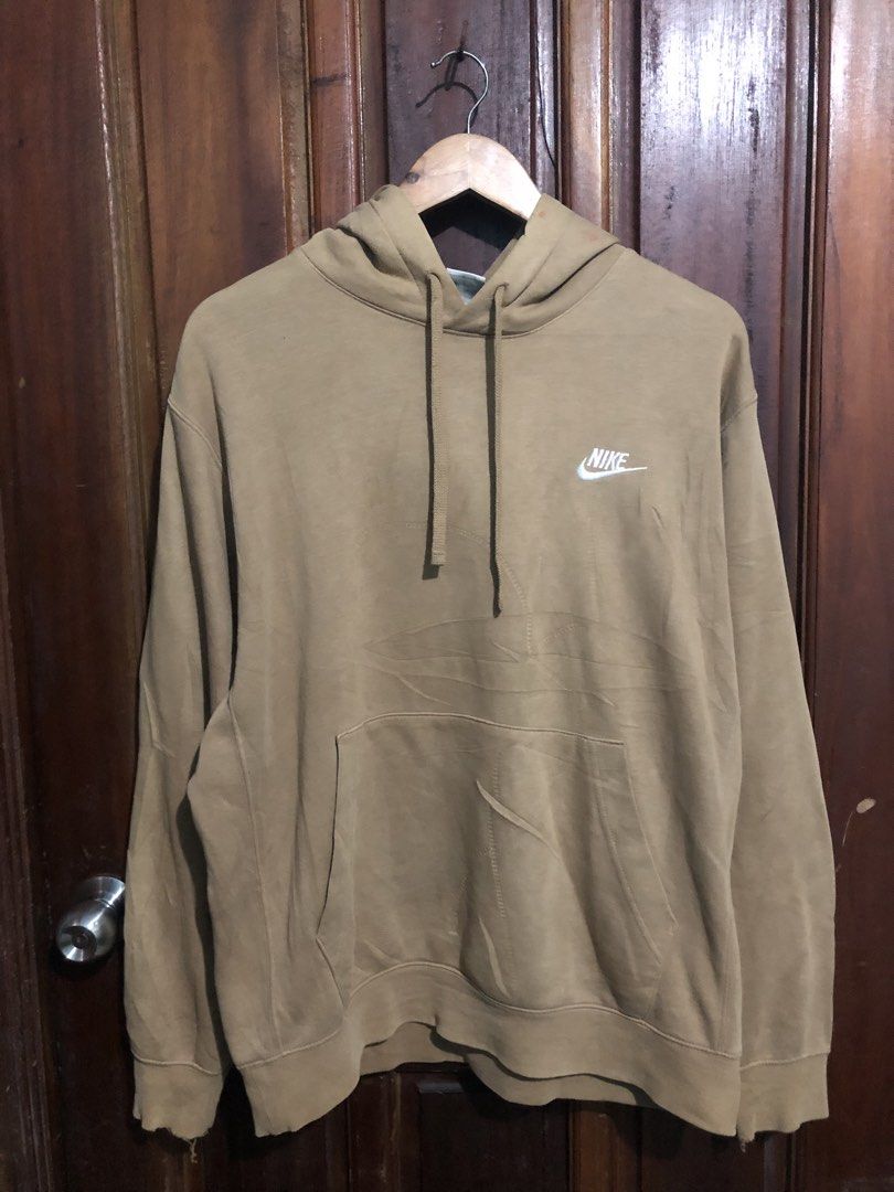 Nike Beige Hoodie (Category: Hoodies) located in Quezon City. Submitted by yeahsource222 (Listing ID 1467529627, Image 1). Description: - Brand: Nike - Style: Classic pullover hoodie with front kangaroo pocket and adjustable drawstring hood - Color: Tan with white embroidered logo on the chest - Size: Large - Condition: Minor wear on ribbed cuffs and hem, with small reddish marks near the neckline - Perfect for: Comfortable everyday streetwear.