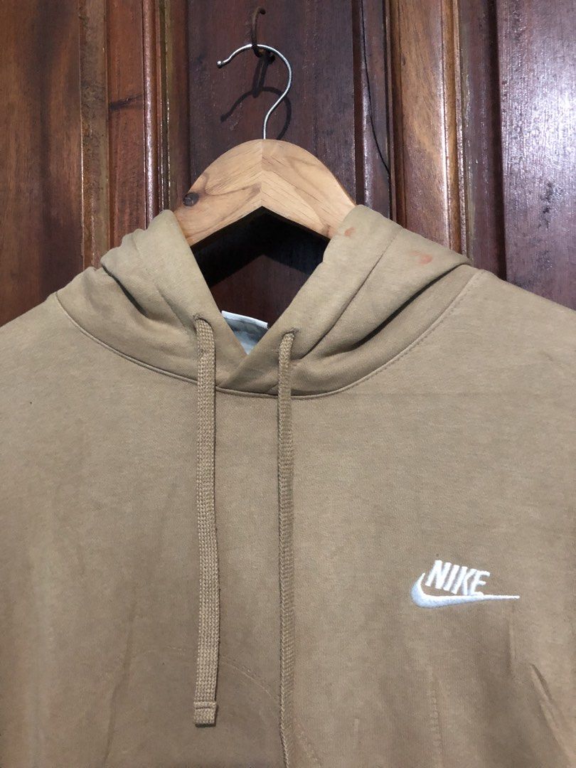 Nike Beige Hoodie (Category: Hoodies) located in Quezon City. Submitted by yeahsource222 (Listing ID 1467529627, Image 2). Description: - Brand: Nike - Style: Classic pullover hoodie with front kangaroo pocket and adjustable drawstring hood - Color: Tan with white embroidered logo on the chest - Size: Large - Condition: Minor wear on ribbed cuffs and hem, with small reddish marks near the neckline - Perfect for: Comfortable everyday streetwear.