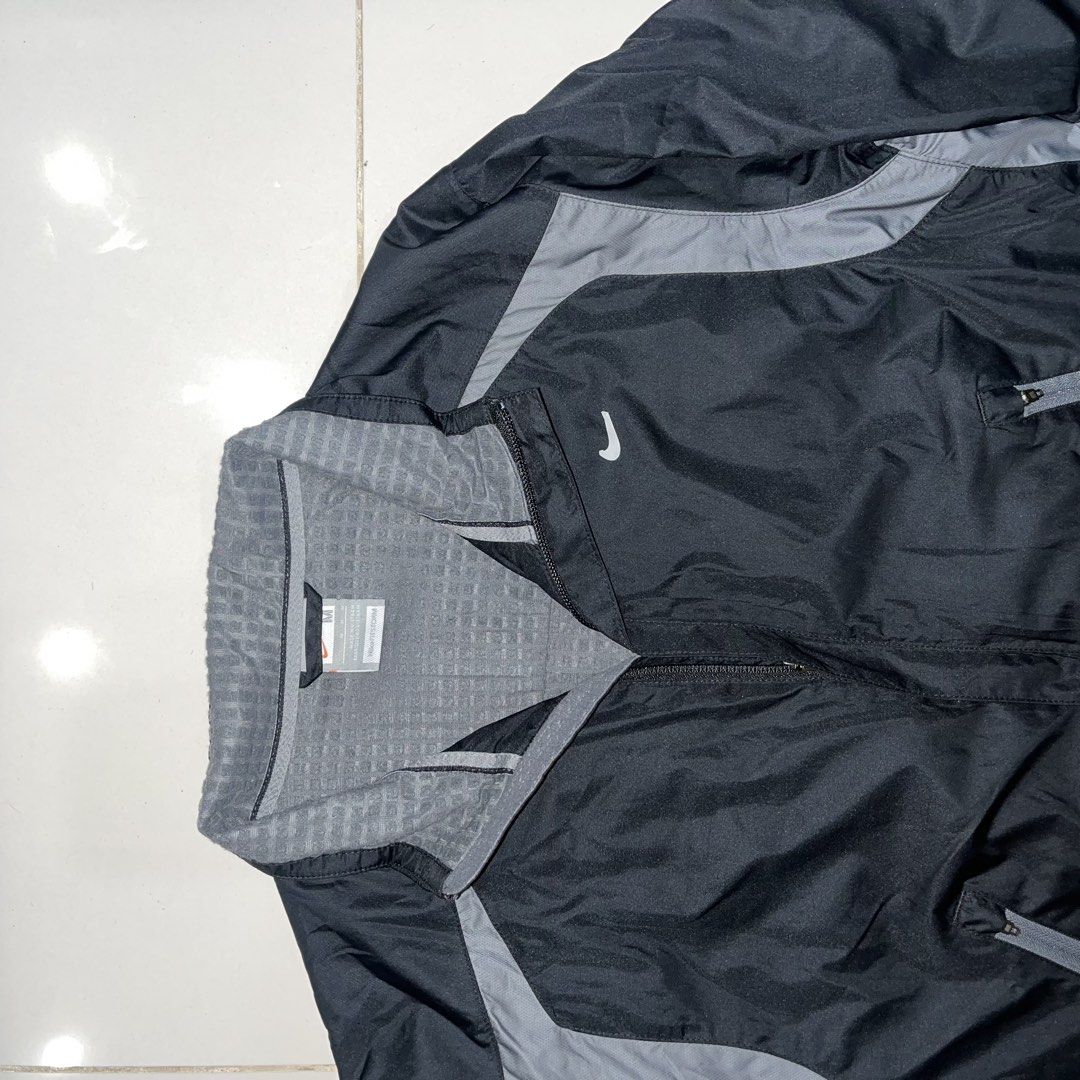 Nike Clima-FIT technical windbreaker track jacket (Category: Coats, Jackets and Outerwear) located in Puerto Princesa. Submitted by sydneyavouz (Listing ID 1467514084, Image 2). Description: - Brand: Nike - Color: Black with grey accent panels - Size: Medium (tag inside collar) - Features: Zip-up closure, high collar with textured grey lining, and zippered front pockets - Branding: White Nike swoosh logo on the right chest - Condition: Excellent,