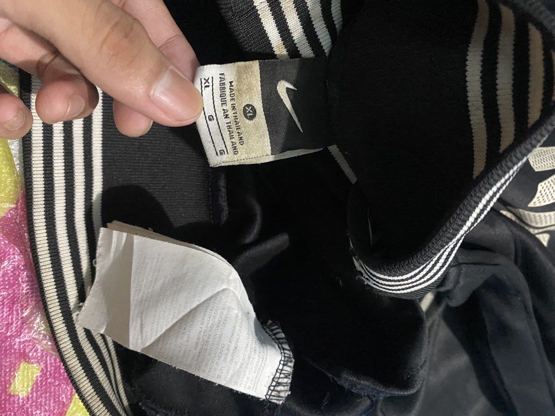 Nike Juventus Black Track Jacket Size XL (Category: Coats, Jackets and Outerwear) located in Manila. Submitted by jerms.thriftah (Listing ID 1467461311, Image 3). Description: - Brand: Nike - Team: Juventus (Crest on chest, large lettering on back) - Color: Black - Size: XL (Made in Thailand) - Features: Full zip closure, stylish striped ribbed collar, cuffs, and hem - Condition: Shows some signs of wear and slight discoloration on the ribbed det