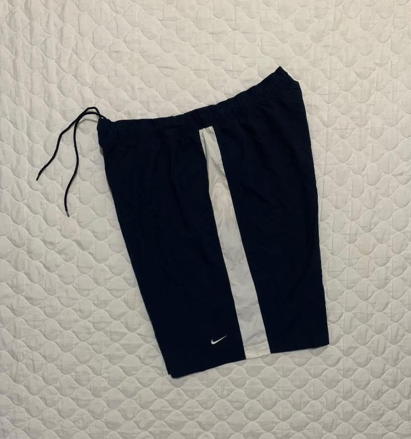 Nike Navy Blue White Striped Athletic Shorts (Category: Shorts) located in Manila. Submitted by jomar_3214 (Listing ID 1467386648, Image 2). Description: - Color: Navy blue with white side stripes - Branding: Small white Nike swoosh and block text near the hem - Fit: Standard fit with an elastic waistband and adjustable drawstring - Material: Lightweight and easy to move in - Versatility: Great for workouts, running errands, or lounging at home.