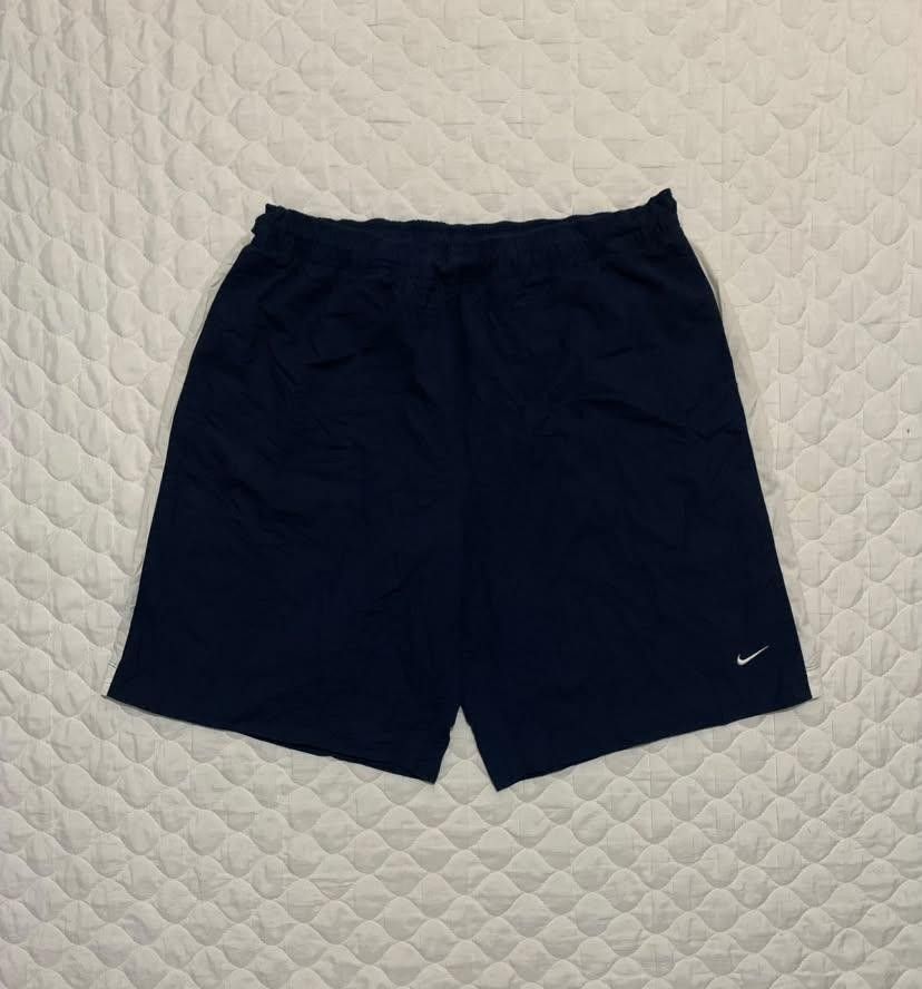 Nike Navy Blue White Striped Athletic Shorts (Category: Shorts) located in Manila. Submitted by jomar_3214 (Listing ID 1467386648, Image 1). Description: - Color: Navy blue with white side stripes - Branding: Small white Nike swoosh and block text near the hem - Fit: Standard fit with an elastic waistband and adjustable drawstring - Material: Lightweight and easy to move in - Versatility: Great for workouts, running errands, or lounging at home.