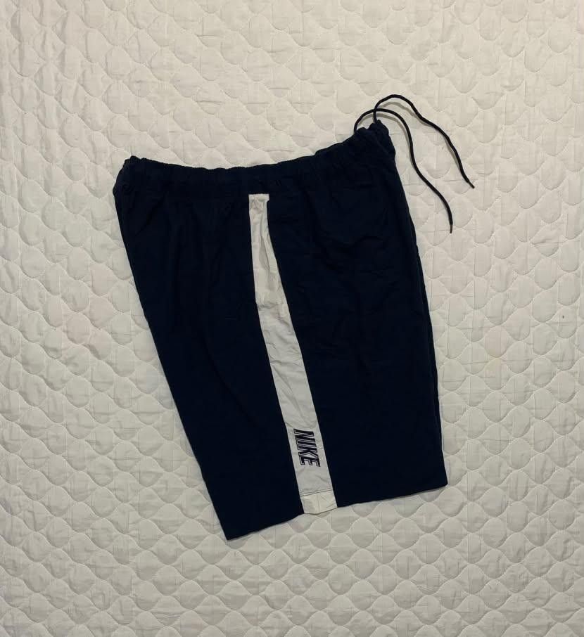 Nike Navy Blue White Striped Athletic Shorts (Category: Shorts) located in Manila. Submitted by jomar_3214 (Listing ID 1467386648, Image 3). Description: - Color: Navy blue with white side stripes - Branding: Small white Nike swoosh and block text near the hem - Fit: Standard fit with an elastic waistband and adjustable drawstring - Material: Lightweight and easy to move in - Versatility: Great for workouts, running errands, or lounging at home.