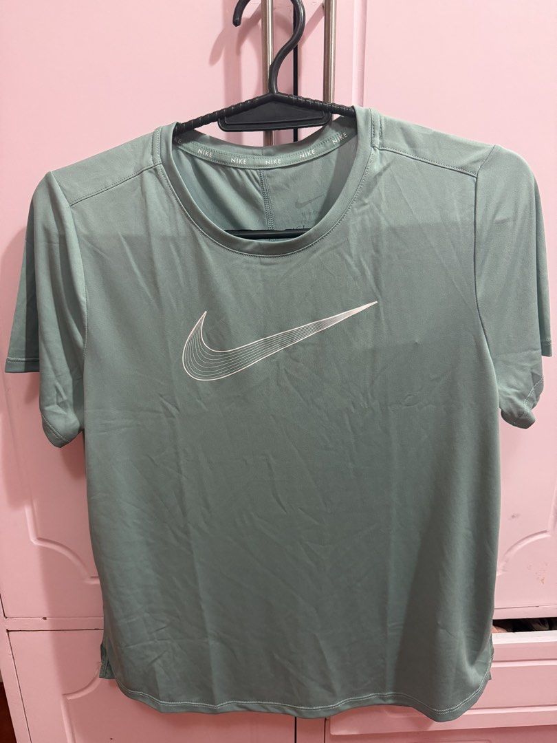 Nike One Training T-Shirt (Category: Shirts) located in Quezon City. Submitted by crazytracyy (Listing ID 1467496517, Image 1). Description: - Brand: Nike One Kids Training Tee - Size: Kids XL (Can fit S Women) - Color: Muted green - Condition: Brand new with original paper tags - Fabric: Dri-FIT moisture-wicking material to keep them dry - Design: Big Swoosh graphic with white striped detailing - Details: Crew neck with repeated Nike text brandi