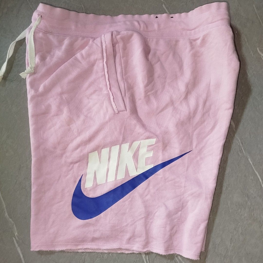 Nike Pink Sweatshorts with Big Logo (Category: Shorts) located in Davao. Submitted by vernoneighty4 (Listing ID 1467477002, Image 2). Description: - Brand: Nike - Item: Pink fleece sweatshorts - Size: Medium (tag attached) - Details: White drawstring waistband, raw cut hem, practical side pockets - Graphic: Large white and blue Nike logo on the left leg - Material: Comfortable cotton blend - Origin: Made in Thailand - Style: Casual streetwear sta