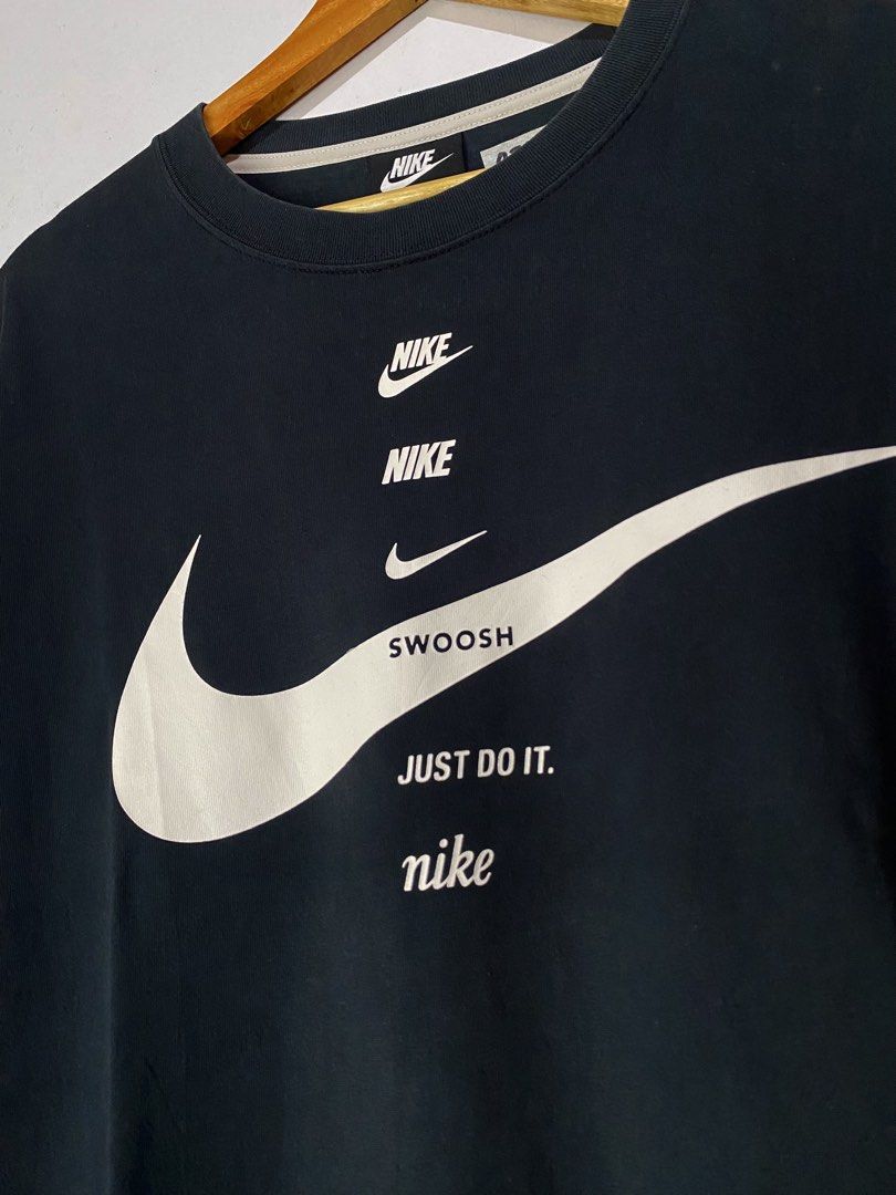 NIKE TSHIRT (Category: Tshirts & Polo Shirts ) located in Jaen. Submitted by oshimamark58418 (Listing ID 1467531489, Image 3). Description: - Brand: Nike - Color: Classic Black with white graphic print - Design: Multiple Nike logos, 'SWOOSH', and 'Just Do It.' text - Size: Large (23 inches width x 28 inches length) - Condition: 4/5 well-maintained pre-loved condition - Material: Comfortable cotton blend, made in China - Style: Casual streetwear /