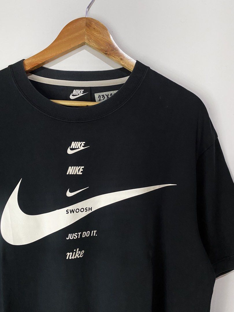 NIKE TSHIRT (Category: Tshirts & Polo Shirts ) located in Jaen. Submitted by oshimamark58418 (Listing ID 1467531489, Image 2). Description: - Brand: Nike - Color: Classic Black with white graphic print - Design: Multiple Nike logos, 'SWOOSH', and 'Just Do It.' text - Size: Large (23 inches width x 28 inches length) - Condition: 4/5 well-maintained pre-loved condition - Material: Comfortable cotton blend, made in China - Style: Casual streetwear /