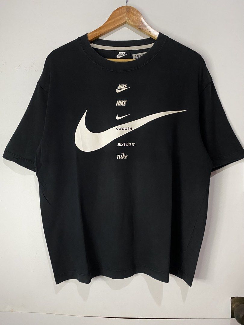 NIKE TSHIRT (Category: Tshirts & Polo Shirts ) located in Jaen. Submitted by oshimamark58418 (Listing ID 1467531489, Image 1). Description: - Brand: Nike - Color: Classic Black with white graphic print - Design: Multiple Nike logos, 'SWOOSH', and 'Just Do It.' text - Size: Large (23 inches width x 28 inches length) - Condition: 4/5 well-maintained pre-loved condition - Material: Comfortable cotton blend, made in China - Style: Casual streetwear /