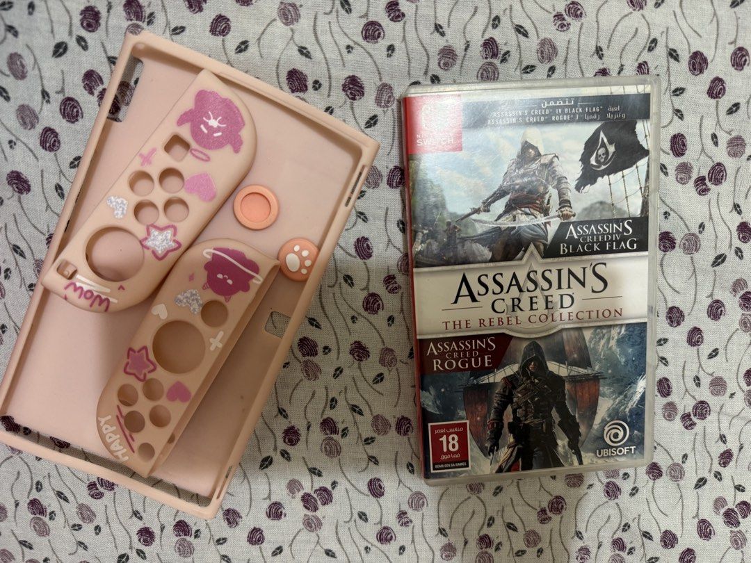 Nintendo Switch OLED Model White with Assassin's Creed (Category: Nintendo) located in Quezon City. Submitted by nclriveraaa (Listing ID 1467564742, Image 3). Description: - Item: Nintendo Switch OLED Model (White) - Condition: 9/10, packed in original box. Working and barely used since I’m in Medical School t__t - Included Hardware: Console, White Joy-Cons, Dock, Power Adapter, Joy-Con Straps - Freebies & Extras: Pink protective case, thumb grip