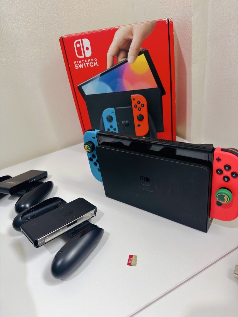 Nintendo Switch OLED - Full Accessories | Screen not working (PLEASE READ DESCRIPTION) (Category: Nintendo) located in Morong. Submitted by jrualat (Listing ID 1467436213, Image 2). Description: Switch OLED but screen is not working. But working 100% when docked. All original accessories included in its box: • Type-C Charger • HDMI Cable • Dock • Joy-cons and wrist strap Addn’l Inclusions: • Dobe Charging Grip (Type-C) • SanDisk 256 GB MicroSD Ca