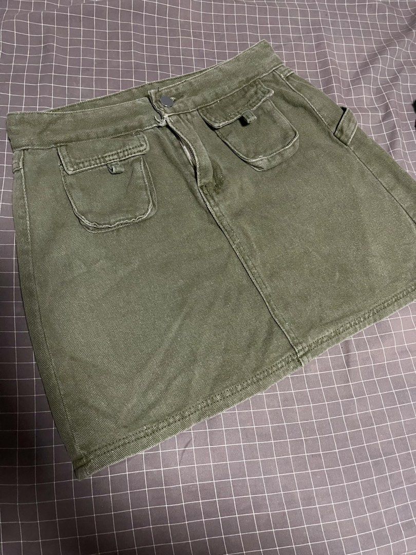 Olive green utility mini skirt with cargo pockets size 27” to 28” (Category: Skirts) located in Calamba. Submitted by goldenprngs101 (Listing ID 1467470621, Image 1). Description: - Color: Olive green - Material: Sturdy cotton twill with great structure - Style: Cargo mini skirt with side loop detail - Closures & Pockets: Front button/zip closure and dual front hip flap pockets - Styling: Perfect to pair with basic tees and tanks for casual outin