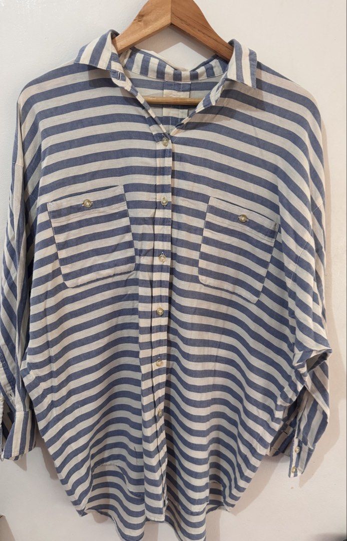 Oversized Striped Button Up Shirt (Category: Blouses) located in Quezon City. Submitted by vibelane_shop (Listing ID 1467427790, Image 2). Description: - Classic blue and white striped pattern - Relaxed, oversized fit with a curved hem - Button-down front featuring a collar and two chest pockets - Soft and lightweight material for all-day comfort - Versatile piece, easy to style with denim or trousers ************ 📝This is not an online store of