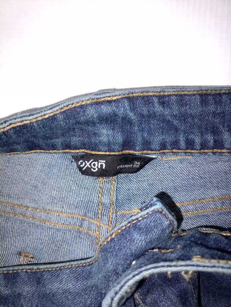 Oxygen Straight Fit Denim Jeans Size 34 (Category: Jeans) located in Caloocan City. Submitted by grandturtle-371b8d (Listing ID 1467397574, Image 3). Description: - Brand/Style: Oxygen straight fit denim jeans - Size: Tagged size 34 - Color/Wash: Dark blue with front thigh fading details - Features: Utility cargo pockets on the sides - Details: Clean stitching and classic button closure - Material: Sturdy and durable fabric construction.