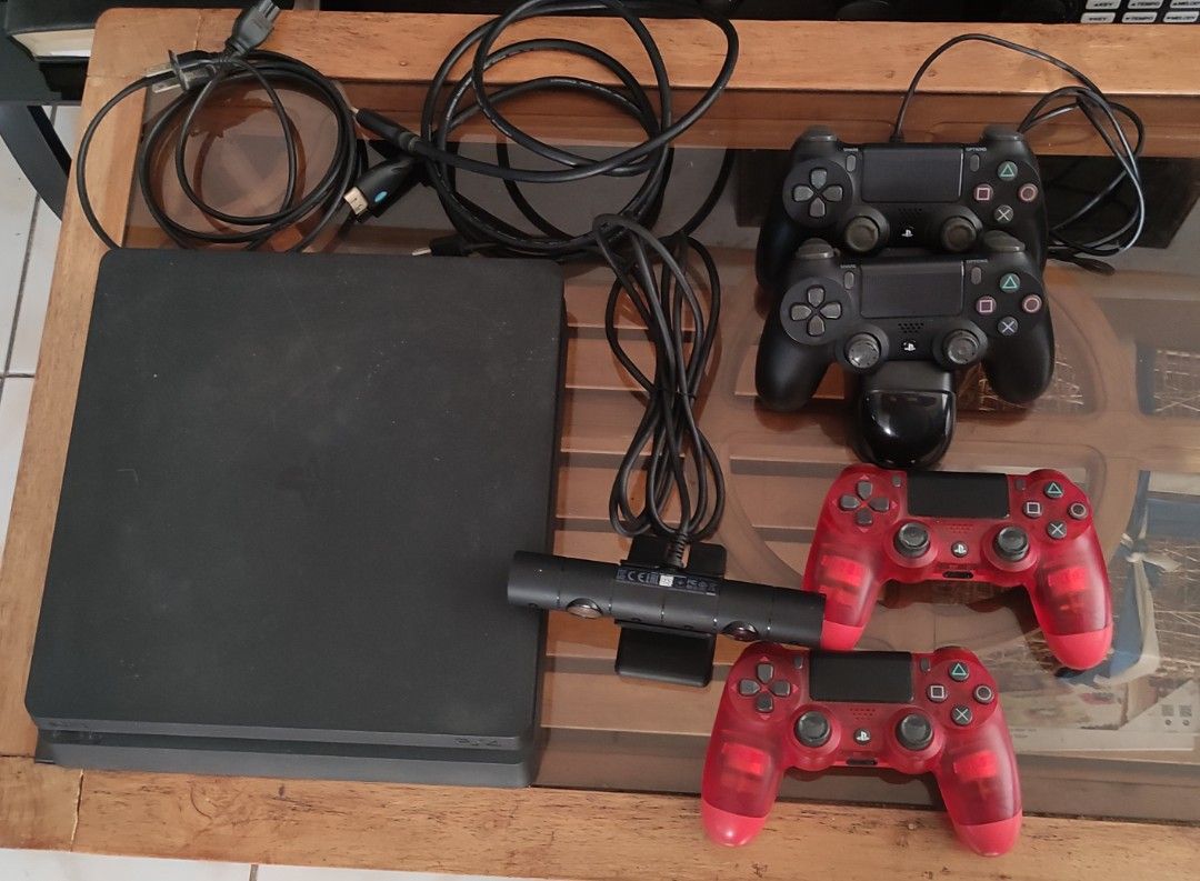 PlayStation 4 Console with 4 Controllers, Camera and 30 Games (Category: PlayStation) located in Dasmarinas. Submitted by jdelacruz0728 (Listing ID 1467573379, Image 1). Description: - Black PS4 console in smooth, working condition - 4 wireless controllers (2 standard black, 2 translucent red) - PlayStation Camera included - Controller charging dock with power and HDMI cables - 30 physical game discs featuring popular titles like Call of Duty, NB