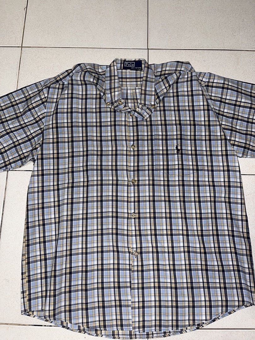 Polo Plaid Button-Down Shirt (Category: Tshirts & Polo Shirts ) located in Manila. Submitted by wildstone_56314f (Listing ID 1467481258, Image 1). Description: - Style: Casual short-sleeve button-down shirt - Pattern: Classic blue, black, and beige plaid - Material: 100% breathable cotton for all-day comfort - Fit: Standard fit with a classic collar and front button closure - Details: Features a single left chest pocket with a small embroidered l