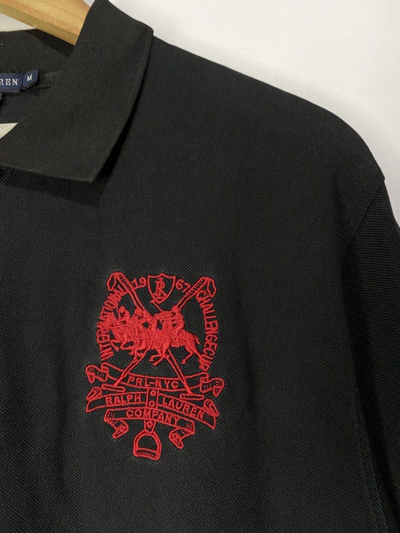 POLOSHIRT (Category: Tshirts & Polo Shirts ) located in Jaen. Submitted by oshimamark58418 (Listing ID 1467522846, Image 3). Description: - Brand: Ralph Lauren - Color: Black with red embroidery - Material: 100% Cotton - Size: 22" width x 27" length (fits Large / Tagged M) - Design: Special chest crest logo & number '5' on sleeve - Condition: Excellent pre-owned condition.