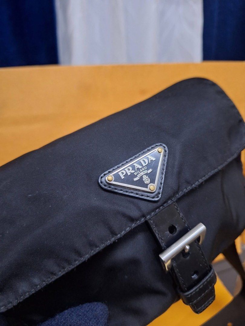 Prada Black Nylon belt bag (Category: Luxury Bags & Wallets) located in Dagupan City. Submitted by makilux.ph (Listing ID 1467377550, Image 2). Description: - Brand: Prada - Material: Durable black nylon with leather trim - Hardware: Silver-tone - Closure: Front flap with leather buckle strap - Logo: Iconic triangular metal logo plaque - Strap: Adjustable heavy-duty black canvas strap with leather accent - Size: Compact and practical for everyday