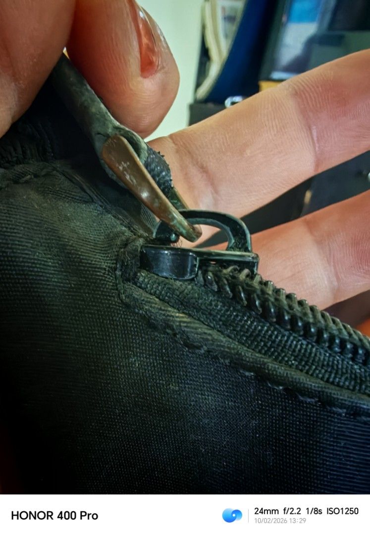 Prada Black Nylon Mini Hobo Bag (Category: Luxury Bags & Wallets) located in Manila. Submitted by cleverwhale_45b7bc (Listing ID 1467375015, Image 2). Description: - Prada nylon shoulder bag in timeless black - Features the iconic enamel triangle logo on the front - Secure zip-top closure - Note on condition: Visible tarnishing and oxidation on the hardware/zipper, plus dust accumulation reflecting its pre-loved, vintage nature - Perfect everyday