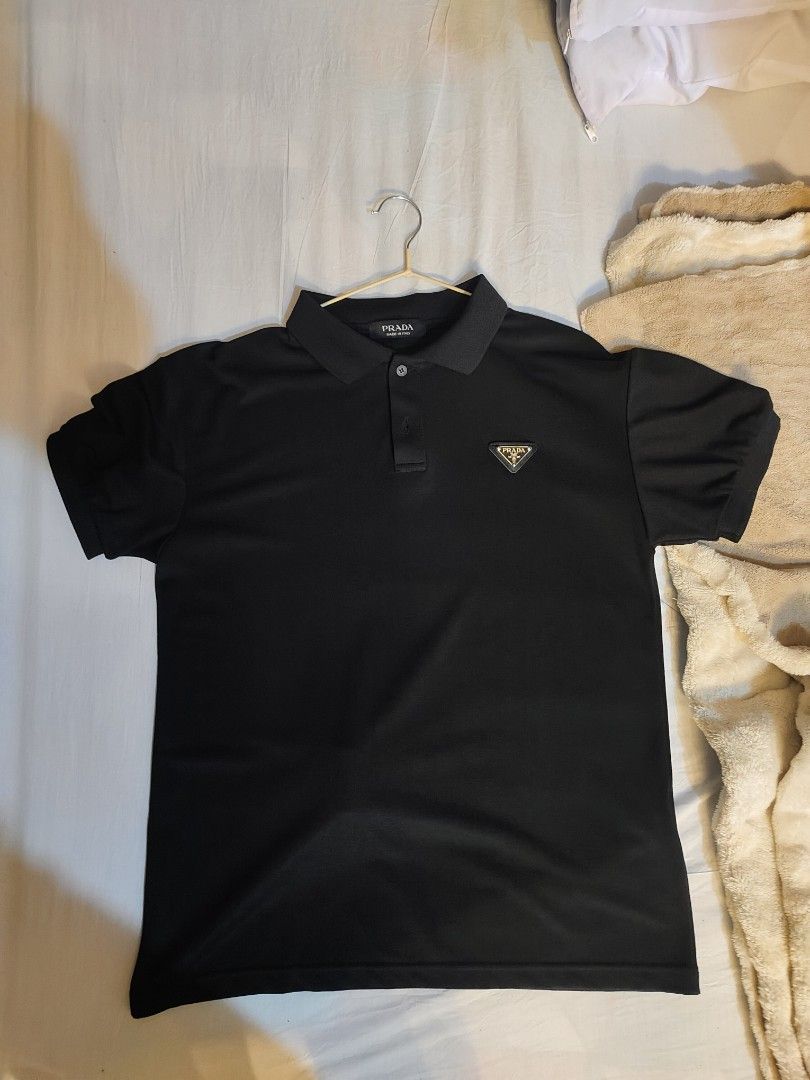 Prada Black Polo Shirt Size L (Category: Tshirts & Polo Shirts ) located in Bayugan. Submitted by boss_rej (Listing ID 1467525727, Image 1). Description: - Brand: Prada - Item: Polo Shirt - Color: Black - Size: L - Condition: Brand new with tags attached - Details: Iconic triangle logo plaque on the left chest, classic collar, and button placket - Style: Versatile staple for casual or smart-casual outfits - Shipping or meetups available across th