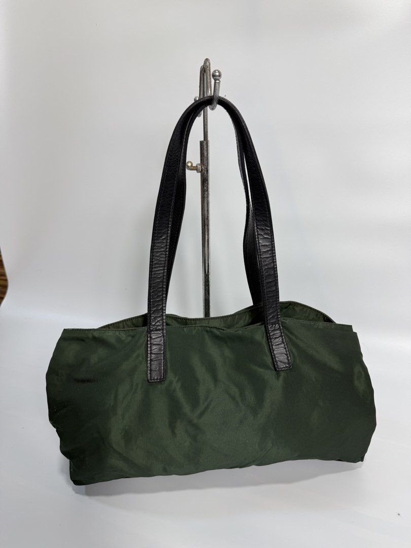 Prada Green Nylon Tote Bag (Category: Luxury Bags & Wallets) located in Dasmarinas. Submitted by arjalaph (Listing ID 1467428223, Image 2). Description: - Authentic Prada nylon tote in a versatile dark green shade - Durable black leather shoulder straps and sleek silver-tone hardware - Iconic Prada metal triangle logo on the front - Spacious interior lined with signature Prada monogram fabric - Includes an interior zipper pocket for secure storag