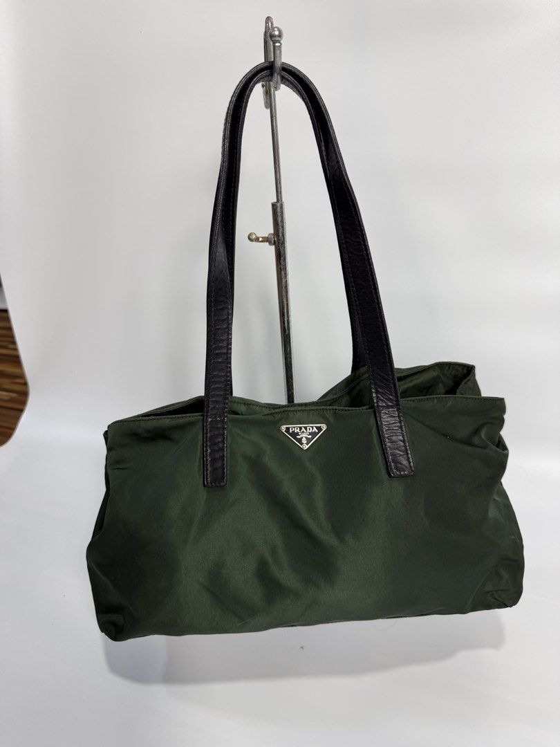 Prada Green Nylon Tote Bag (Category: Luxury Bags & Wallets) located in Dasmarinas. Submitted by arjalaph (Listing ID 1467428223, Image 1). Description: - Authentic Prada nylon tote in a versatile dark green shade - Durable black leather shoulder straps and sleek silver-tone hardware - Iconic Prada metal triangle logo on the front - Spacious interior lined with signature Prada monogram fabric - Includes an interior zipper pocket for secure storag