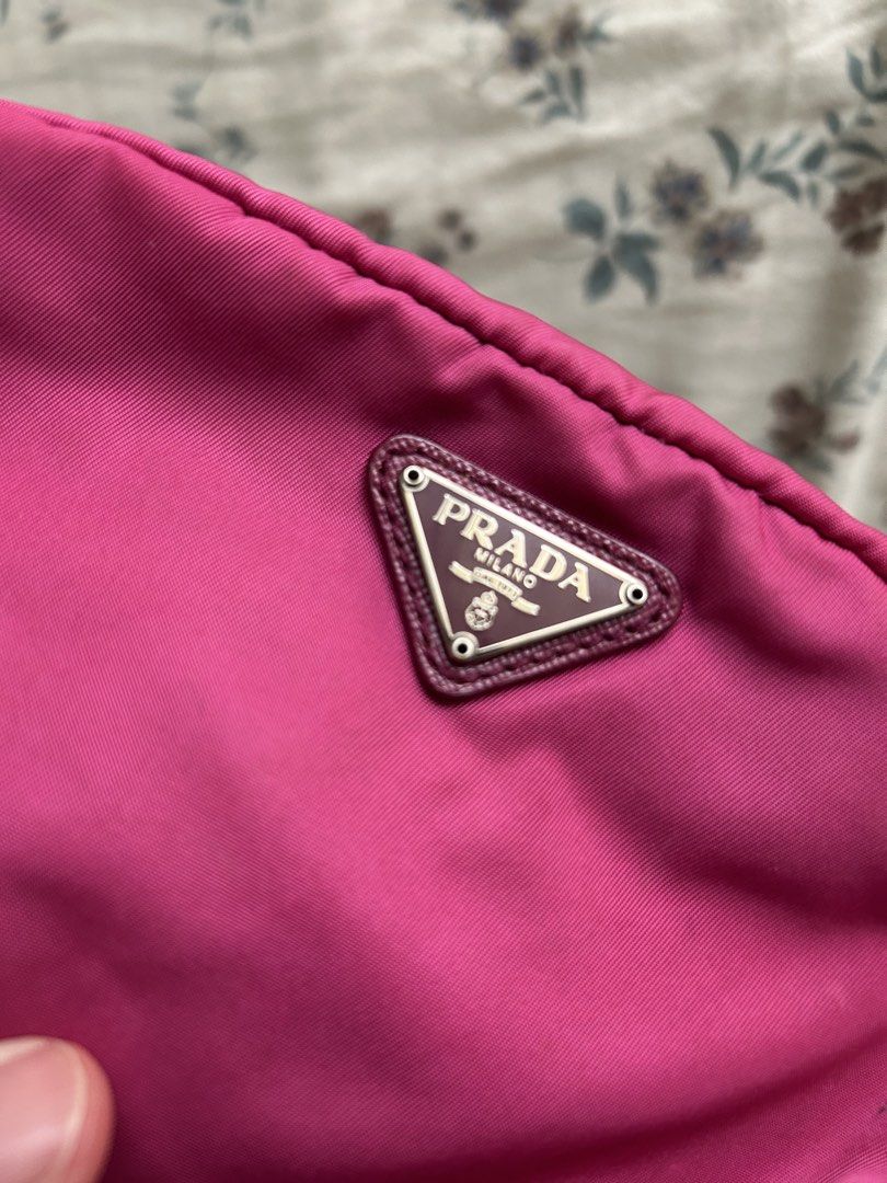 Prada Nylon Pink Cosmetic Pouch (Category: Purses & Pouches) located in Manila. Submitted by ashleyrosedg (Listing ID 1467389986, Image 2). Description: - Brand: Prada - Color: Bright pink - Material: Durable nylon with Saffiano leather trim - Closure: Top zipper closure with matching pink lining - Details: Iconic triangle logo plaque on the front and interior leather tag - Usage: Compact size, ideal for daily essentials, makeup, or travel organi