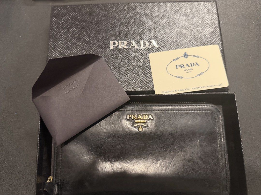 Authentic Prada Vitello Shine Zip Around Wallet Black (Category: Luxury Bags & Wallets) located in Paranaque City. Submitted by silverforest.13 (Listing ID 1467363642, Image 1). Description: - Authentic Prada long zip-around wallet (Model 1M0506) - Material: Luxurious black Vitello Shine leather with gold hardware lettering - Condition: Clean interior and smooth, fully functional zipper - Inclusions: Original box, authenticity card, and store rec