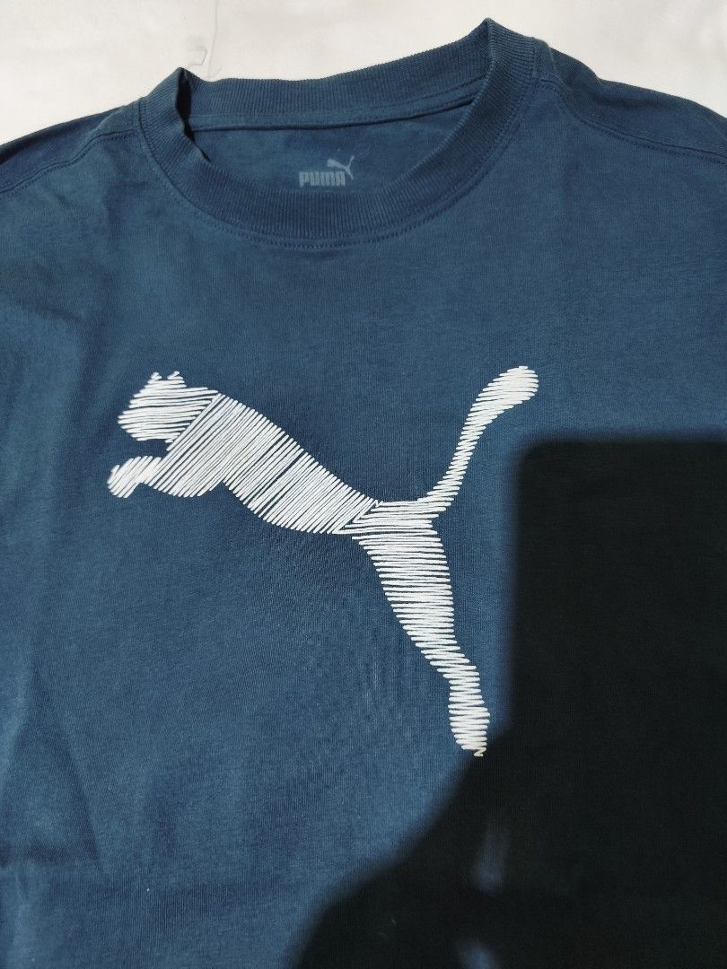 Puma Blue Graphic T-shirt Size M (Category: Shirts) located in Quezon City. Submitted by tintinarms (Listing ID 1467526641, Image 2). Description: - Brand: Puma ladies - Color: Blue with white sketched graphic logo - Size: Medium (Regular fit) - Material: 100% Cotton (Soft and comfortable feel) - Design: Crew neck, short sleeves - bust size - 19 inches.