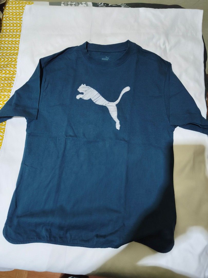 Puma Blue Graphic T-shirt Size M (Category: Shirts) located in Quezon City. Submitted by tintinarms (Listing ID 1467526641, Image 1). Description: - Brand: Puma ladies - Color: Blue with white sketched graphic logo - Size: Medium (Regular fit) - Material: 100% Cotton (Soft and comfortable feel) - Design: Crew neck, short sleeves - bust size - 19 inches.
