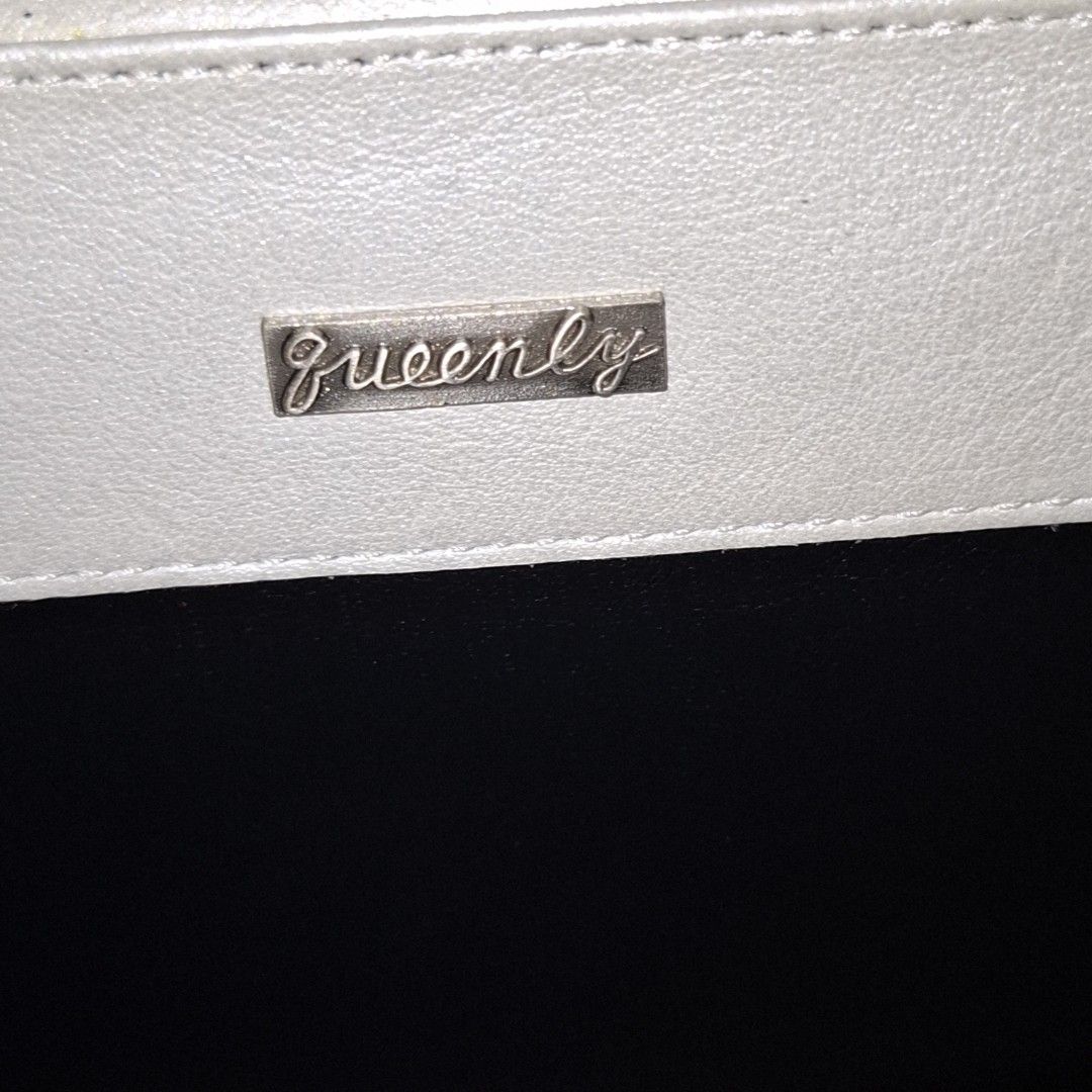 Queenly White Semi-Circle Clutch Bag with Leaf Charm (Category: Clutches) located in Don Carlos. Submitted by PphiXi_Finds (Listing ID 1467439199, Image 3). Description: - Brand: Queenly - Style: White semi-circle clutch bag with front flap - Versatile: Includes a removable metal chain strap for shoulder or hand carry - Details: Magnetic closure, black inner lining, and a cute dangling silver leaf charm - Condition: Minor wear visible near the in
