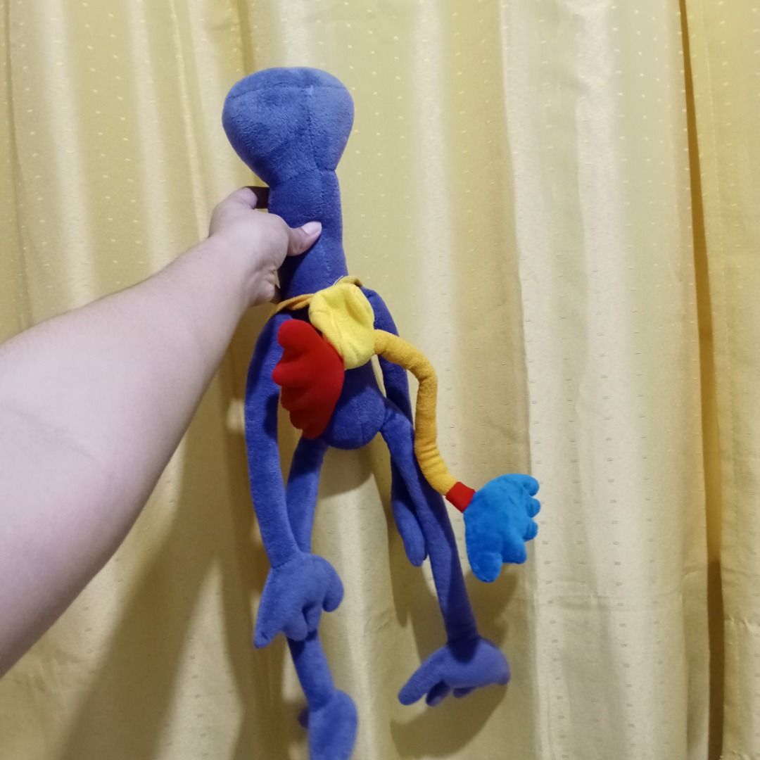 Rainbow Friends Roblux Stuff Toy (Category: Plushies & Soft Toys) located in Quezon City. Submitted by trinket_cat (Listing ID 1467389593, Image 2). Description: - Adorable purple plush monster with a big head and long dangling limbs - Features fun multi-colored accessories: yellow collar, red back wing, and yellow tail with a blue hand - Made from ultra-soft, huggable fabric - Clean and well-maintained condition - Perfect for quirky toy collecto