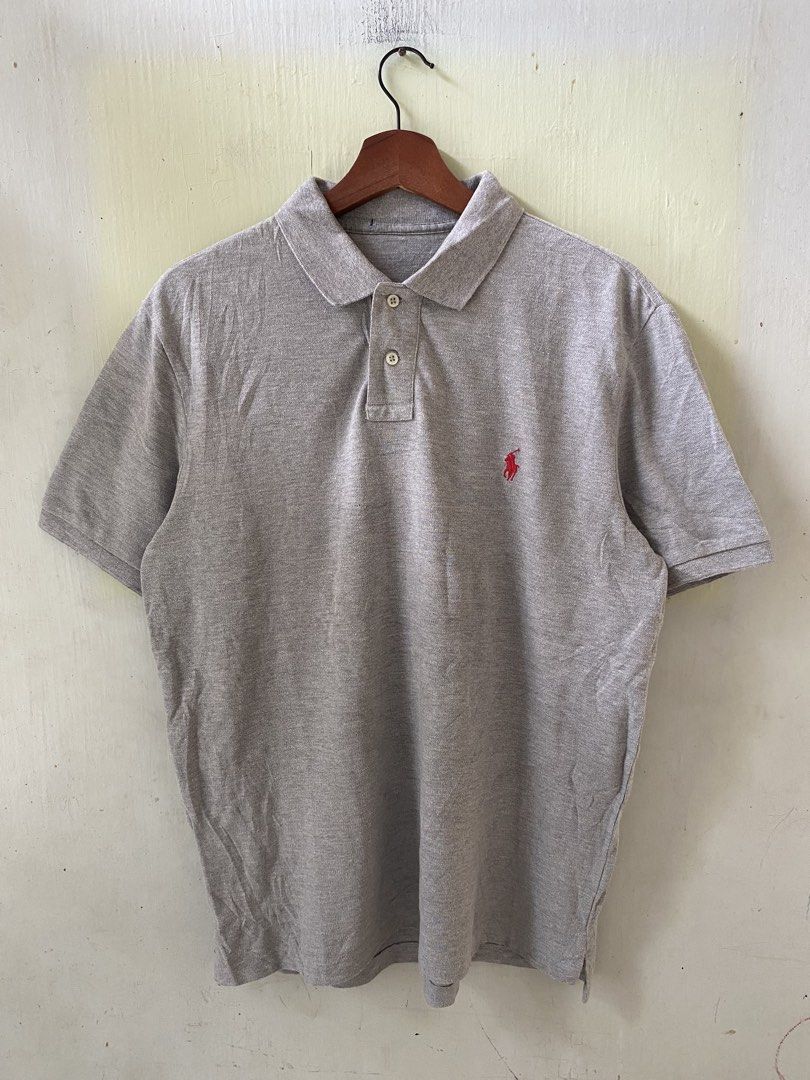 Ralph Lauren Grey Polo Shirt (Category: Tshirts & Polo Shirts ) located in Pandi. Submitted by nasya_thrift_collection2023 (Listing ID 1467413697, Image 1). Description: - Brand: Ralph Lauren - Color: Grey - Material: 100% Cotton (Made in China) - Features: Short sleeves, classic collar with 2 buttons, signature red embroidered pony logo on the chest - Condition: Clean fabric throughout, excellent pre-loved condition.