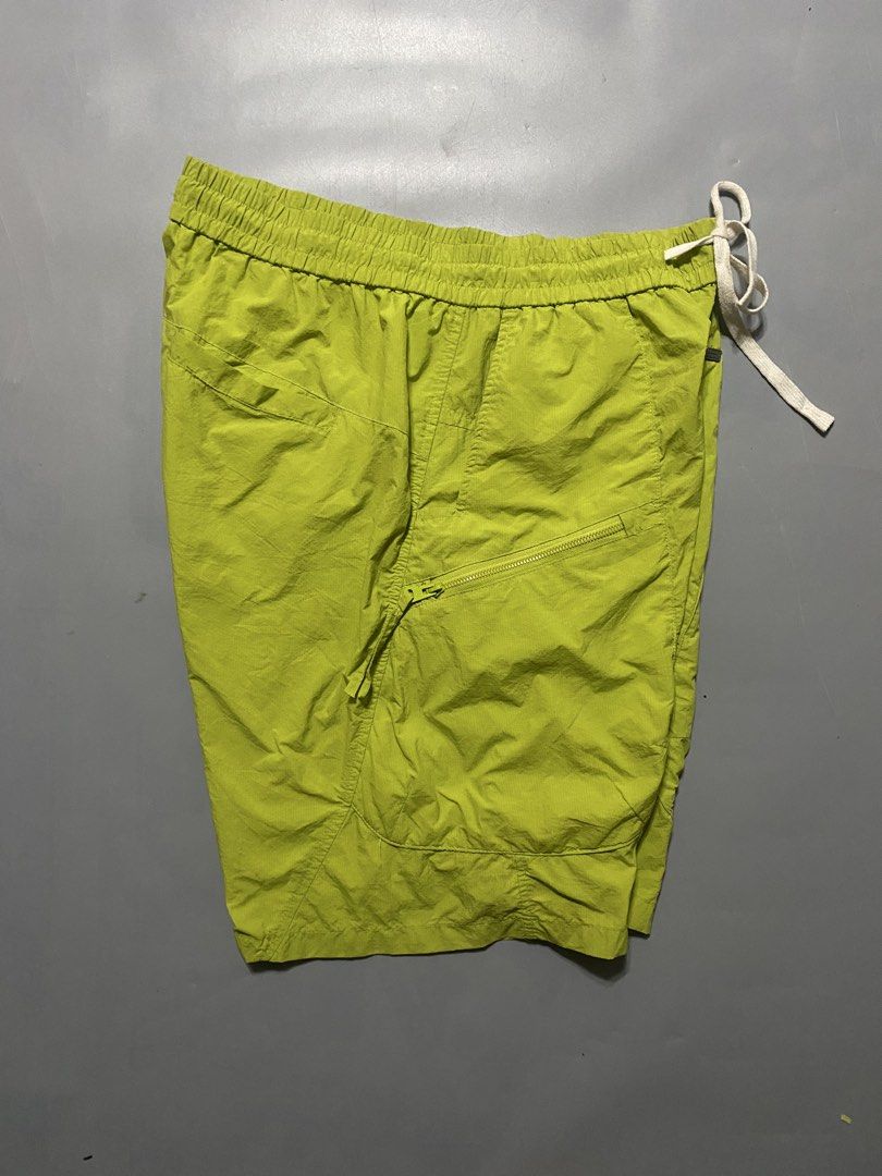 Random Outdoor short (Category: Shorts) located in Manila. Submitted by delunakenn94368 (Listing ID 1467509523, Image 3). Description: - Color: Lime green with a crinkled texture - Material: Lightweight nylon, ideal for warm weather - Fit: Relaxed fit through the legs with an elastic waistband and thick white drawstring - Pockets: Two large front cargo pockets featuring slanted zippers - Details: Small woven logo tag near the hem - Style: Great f