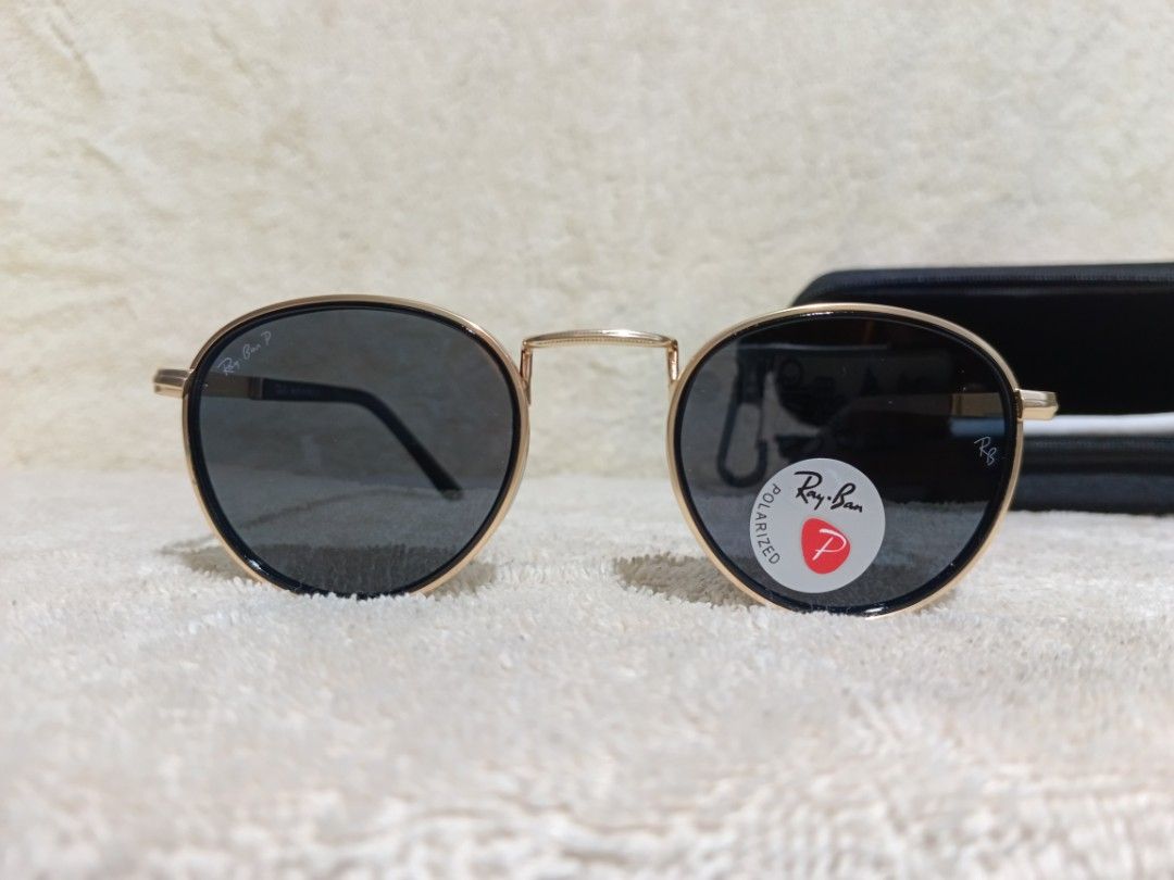 Ray-Ban Polarized Sunglasses Black Gold Round Frames (Category: Sunglasses & Eyewear) located in Cavite. Submitted by navias (Listing ID 1467547179, Image 1). Description: - Brand: Ray-Ban - Frame: Black and gold round frames with textured gold temples - Lenses: Polarized dark lenses with Ray-Ban logo - Origin: Made in Italy - Inclusions: Black zippered hard case and cleaning cloth - Condition: Excellent.