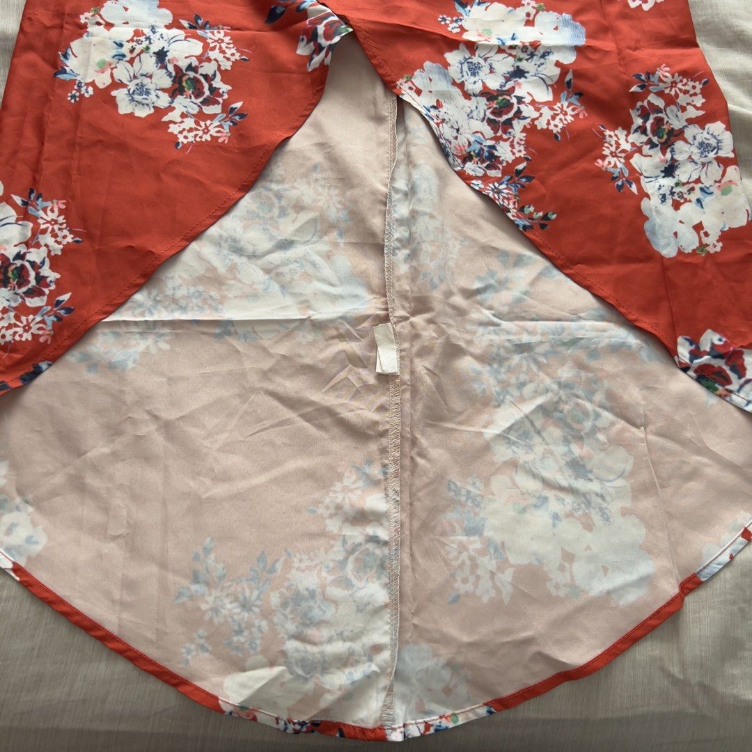 Red Floral Wrap Beach Skirt (Category: Skirts) located in Pasig City. Submitted by jenscloset86 (Listing ID 1467397167, Image 3). Description: Size: Free Size • Red with white and blue floral print • Midi length with a stylish curved hem • 100% lightweight and flowy polyester • Adjustable self-tie waist straps • Perfect for casual days, beach trips, or weekend dates Measurement (in inches): Length: 39” Waist: 25-30” adjustable tie.