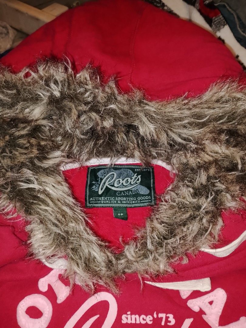 Roots Canada Red Fur Lined Hoodie Size Small (Category: Coats, Jackets and Outerwear) located in Cebu City. Submitted by pettydoll_24 (Listing ID 1467578719, Image 2). Description: - Brand: Roots Canada - Color: Bright red with pink Roots Athletics front graphic - Size: Small - Features: Fuzzy faux fur trim around the hood, white drawstrings, and branded metal eyelets - Condition: Excellent pre-loved condition - Perfect for casual and cozy street