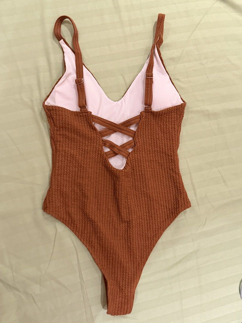 Rust Orange Crinkle One-Piece Swimsuit with Crossback Straps (Category: Bikinis & Swimsuits) located in Quezon City. Submitted by caathhx_ (Listing ID 1467510759, Image 2). Description: - Color: Rich rust orange with light pink lining - Material: Textured crinkle fabric - Design: Deep v-neck front and back, high-cut leg - Details: Adjustable shoulder straps with cute crisscross back - Perfect for: Beach trips and pool days.