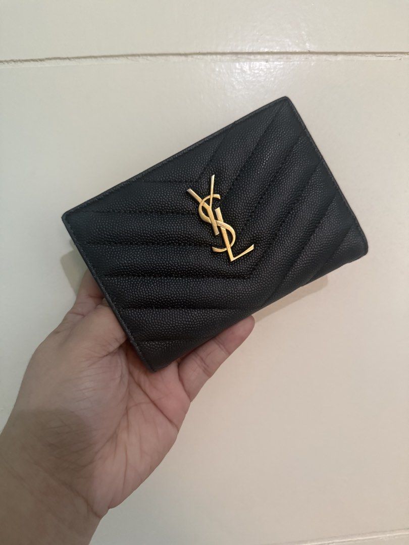 Saint Laurent YSL Monogram Compact Bi-fold Wallet Black (Category: Luxury Bags & Wallets) located in Malabon City. Submitted by levineabby (Listing ID 1467398426, Image 2). Description: - Brand: Saint Laurent (YSL) - Material: Black quilted leather with gold hardware - Hardware: Gold interlocking YSL logo and interior gold stamp - Closure: Secure snap button - Interior: Card slots and a convenient coin compartment - Size: Compact, fits easily int