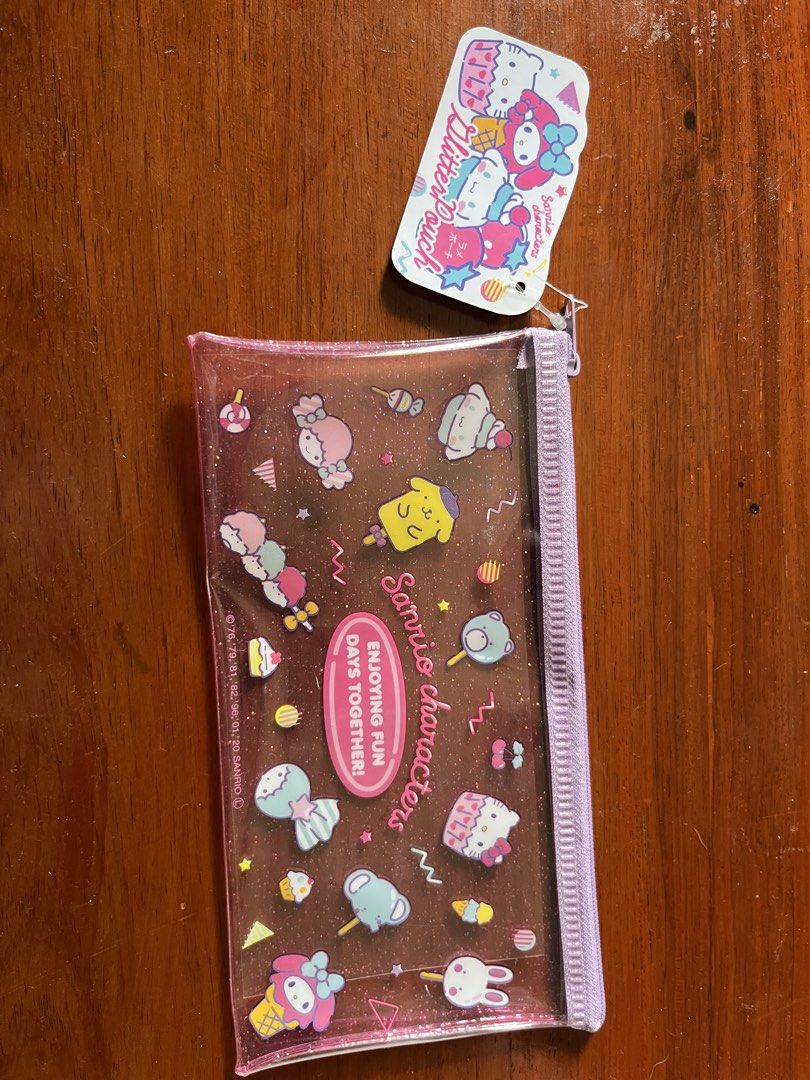 Sanrio Characters Glitter Pouch Clear Case (Category: Stationery & School Supplies) located in Malolos. Submitted by mavi.annxo (Listing ID 1467388750, Image 1). Description: - Authentic Sanrio clear pencil case featuring Kitty, My Melody, and Little Twin Stars - Sparkling glitter details embedded in the transparent material - Stylish purple zipper closure along the side - Brand new with original tag still attached to the pull tab - Multi-purpose