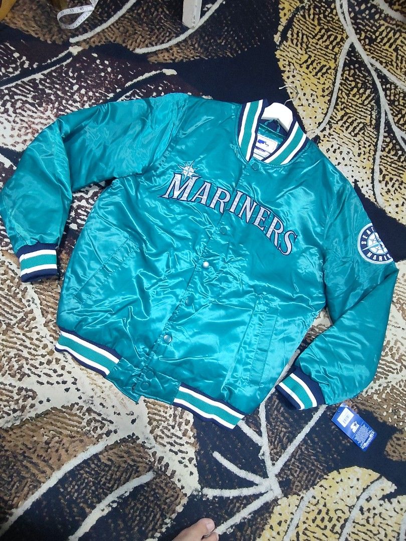 Seattle Mariners Starter Satin Bomber Jacket Teal (Category: Coats, Jackets and Outerwear) located in Pandi. Submitted by yanyan_apparel.store08 (Listing ID 1467374509, Image 2). Description: - Official Seattle Mariners satin bomber jacket in classic teal - Snap button front closure for easy wear - Classic striped rib knit collar, cuffs, and hem - Bold embroidered team lettering across the chest - Authentic team patch logo on the left sleeve - Or