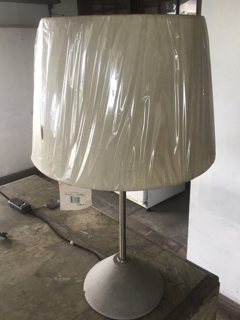 Seed Design Table Lamp Creme (Category: Lighting) located in Manila. Submitted by roberto.enriquez (Listing ID 1467588002, Image 3). Description: - Brand: Seed Design - Color: Creme lampshade with grey cone-shaped base - Cord: Black textile cord - Condition: Like new, pleated fabric lampshade still wrapped in original protective packaging - Specifications: Model UCM0259OR3, E27 bulb up to 60W - Origin: Made in Taiwan.